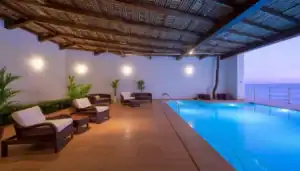 a swimming pool with chairs and a tree in the middle