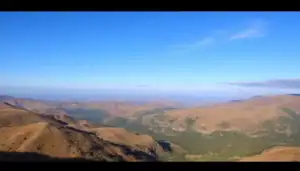 a landscape of a valley with hills and trees