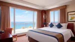 a room with a bed and a view of the ocean